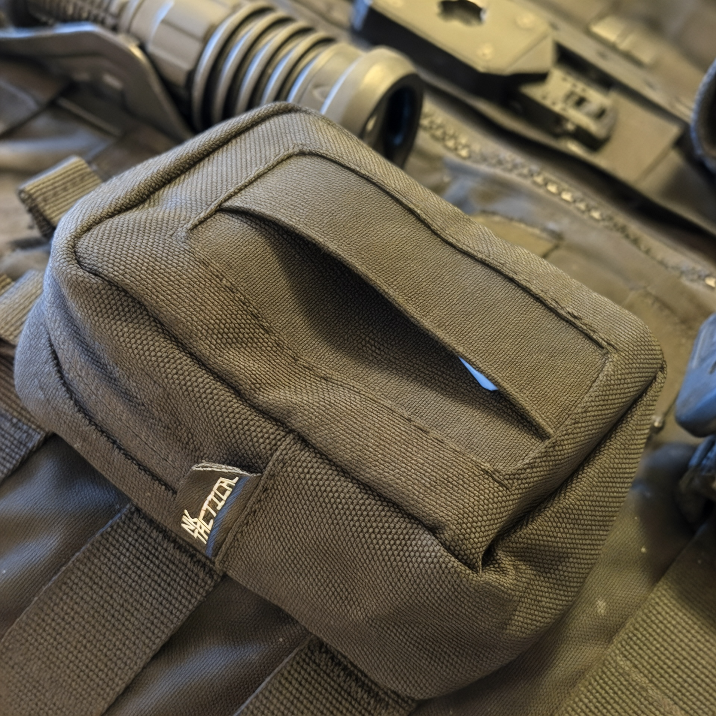 GloveNest MOLLE disposable glove pouch mounted on tactical vest with front glove dispensing opening