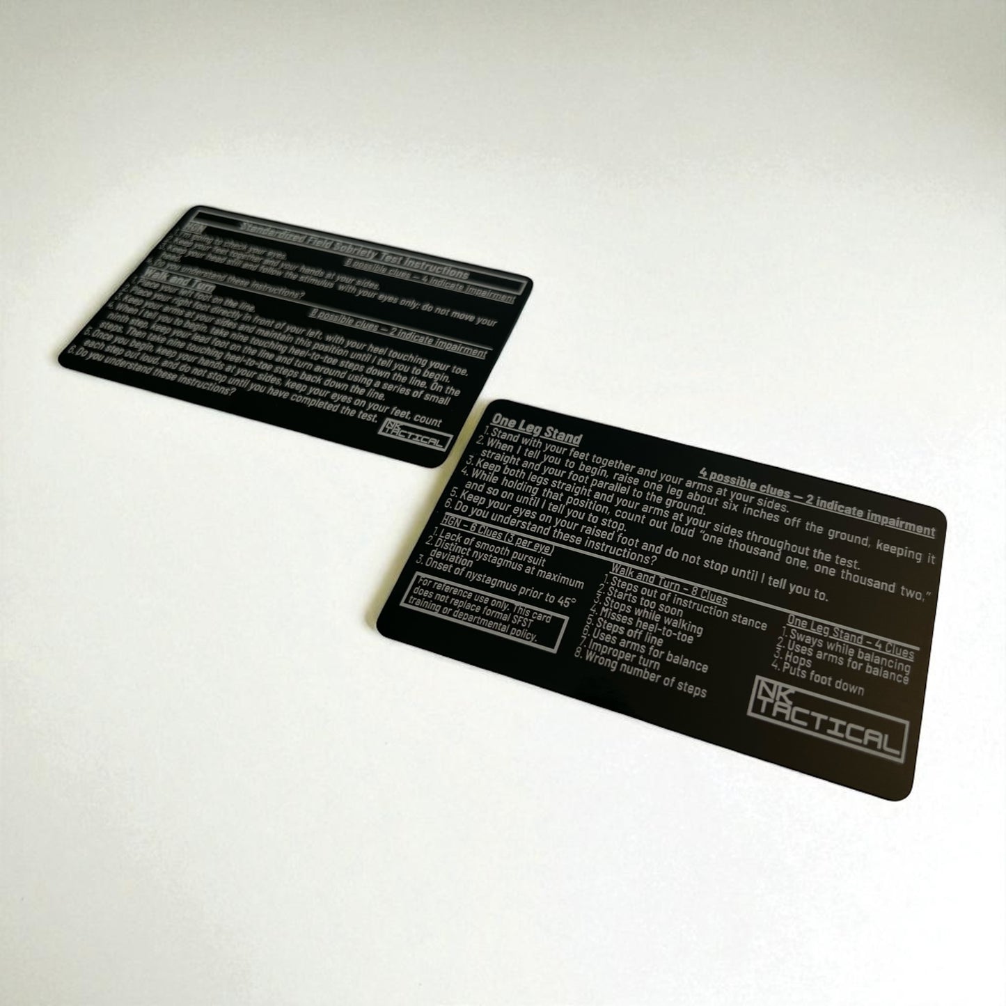 Angled photo of two anodized aluminum SFST reference cards highlighting laser-engraved text and durable black finish.