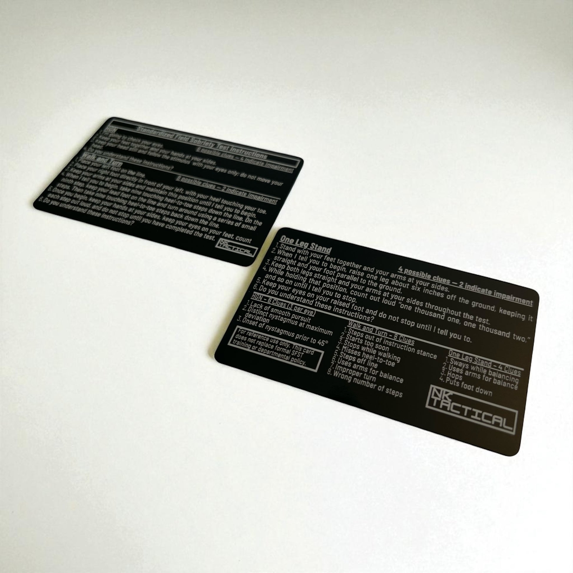 Angled photo of two anodized aluminum SFST reference cards highlighting laser-engraved text and durable black finish.
