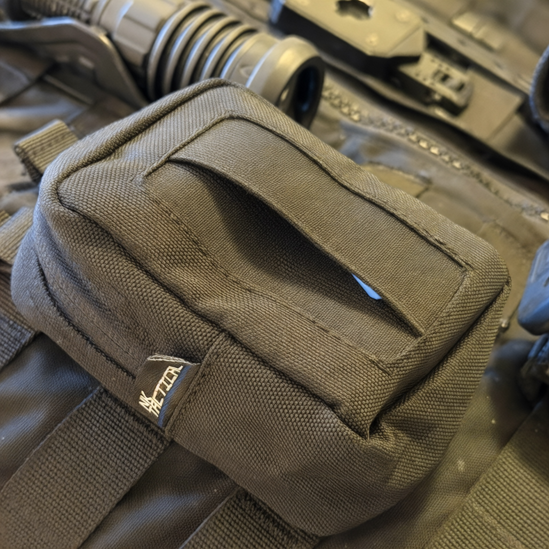 GloveNest MOLLE disposable glove pouch mounted on tactical vest with front glove dispensing opening